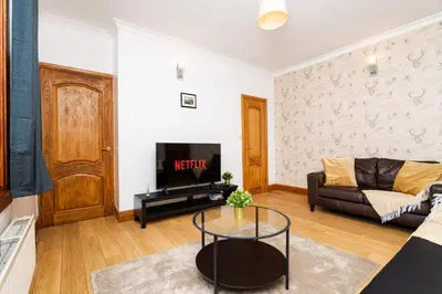 a living room with a couch and a tv at 2Bed Upper Cottage-Street Parking-by Holiday Homes in Falkirk