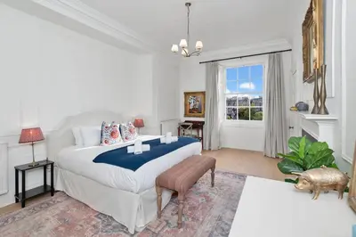 a white bedroom with a bed and a couch at GuestReady - Elegant Edinburgh Retreat in Edinburgh