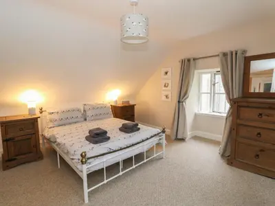a bedroom with a white bed and a window at The Cottage in Perth