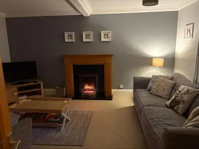a living room with a couch and a fireplace at The Cottage in Perth