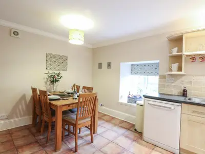 a kitchen with a table and chairs in a room at The Cottage in Perth