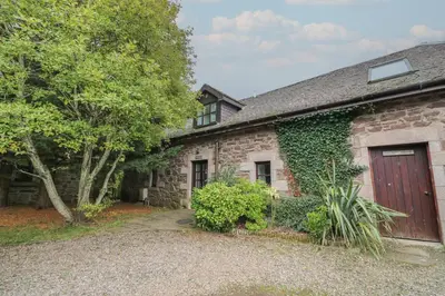 a stone house with a red door at The Cottage in Perth