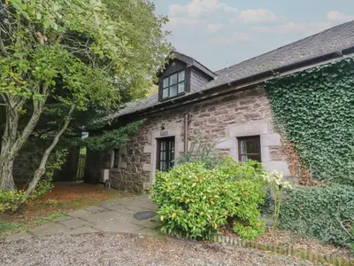 an external view of a stone house with ivy at The Cottage in Perth