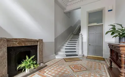 a living room with a fireplace and a staircase at Charming West End Flat in Edinburgh