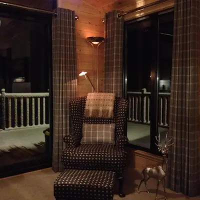 a living room with a chair and a lamp and a antelope at Sòghail Luxury Lodge and Balquhidder Mhor with Hot Tub in Kingshouse