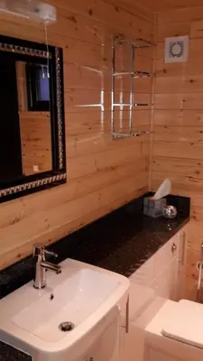 a bathroom with a sink and a mirror at Sòghail Luxury Lodge and Balquhidder Mhor with Hot Tub in Kingshouse