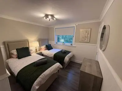 a room with two beds and a table at Modern 2BR Sleeps 4 Central Scotland with Parking in Banknock