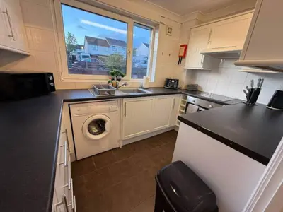 a kitchen with a sink and a washing machine at Modern 2BR Sleeps 4 Central Scotland with Parking in Banknock