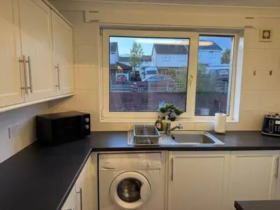 a kitchen with a sink and a washing machine at Modern 2BR Sleeps 4 Central Scotland with Parking in Banknock