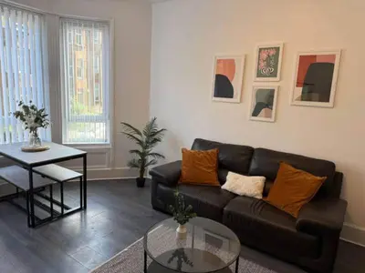 a living room with a couch and a table at 2BR Flat with Parking Near Glasgow Green and Parks in Glasgow