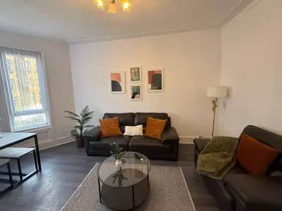a living room with a couch and a table at 2BR Flat with Parking Near Glasgow Green and Parks in Glasgow