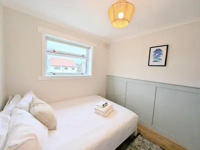 a small bedroom with a white bed and a window at Newly Refurbished 3 Bed House with 2-Sided Wood Burner and Garden in Edinburgh in Edinburgh