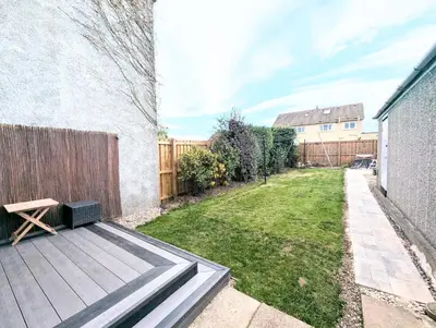 a backyard with a wooden bench and a fence at Newly Refurbished 3 Bed House with 2-Sided Wood Burner and Garden in Edinburgh in Edinburgh