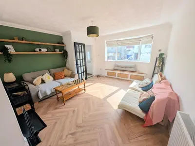 a living room with a couch and a table at Newly Refurbished 3 Bed House with 2-Sided Wood Burner and Garden in Edinburgh in Edinburgh