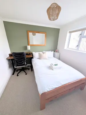a bedroom with a bed with a desk and a chair at Newly Refurbished 3 Bed House with 2-Sided Wood Burner and Garden in Edinburgh in Edinburgh