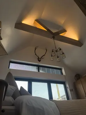 a bedroom with a ceiling fan and a bed and a window at Pink Cottage in Kirkcowan