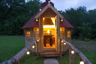 a small wooden dog house with lights in the grass at Wildcat Lodge in Kilmichael Glassary
