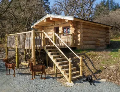 a log cabin with a staircase leading up to it at Pine Marten in Kilmichael Glassary
