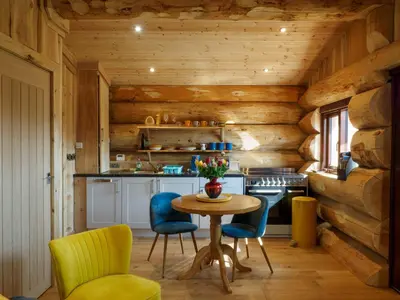 a kitchen with wooden walls and a table and chairs at Pine Marten in Kilmichael Glassary