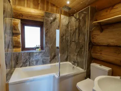 a bathroom with a bath tub and a toilet at Pine Marten in Kilmichael Glassary