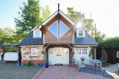 a tiny house with a pitched roof at Lily Wood Cottage outside Hurlford in Hurlford