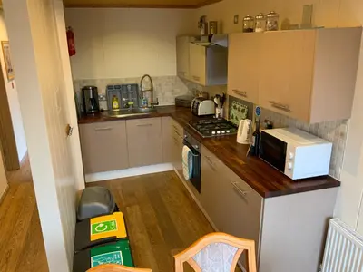 a small kitchen with a stove and a microwave at Skye Lodge in Tighnabruaich