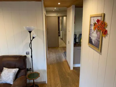 a living room with a couch and a lamp at Skye Lodge in Tighnabruaich
