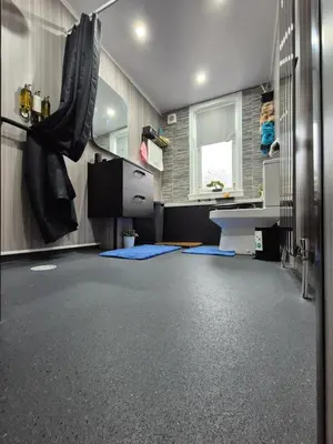 a bathroom with a black floor and a sink at Ta'Pinu House and Spa in Horse Isle
