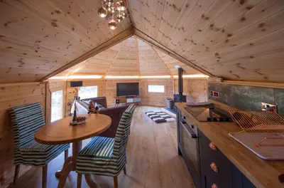 a kitchen and dining room of a tiny house at Woodcock Lodge in Kilmichael Glassary