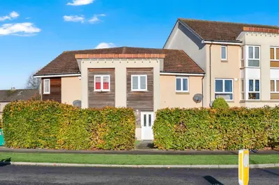a house with a hedge in front of a street at Vacant Nests Dunfermline WiFi Priv-Parking in Fife