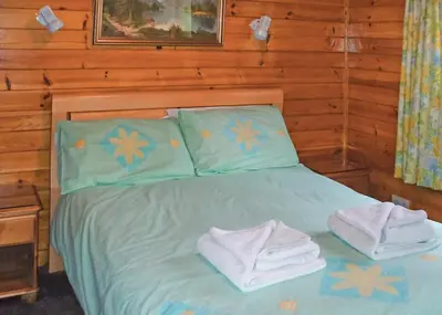 a bedroom with a bed with towels on it at Hideaway Lodges in Boʼness