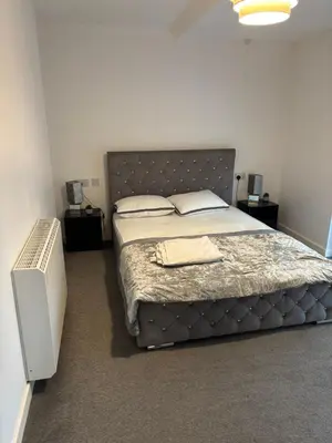 a bedroom with a large bed with a large headboard at One Bedroom Apartment in Greenwich Peninsula in Moffat