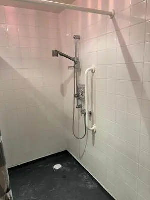 a shower stall in a bathroom with white tiles at One Bedroom Apartment in Greenwich Peninsula in Moffat