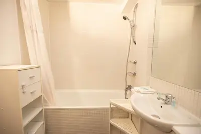 a bathroom with a tub and a sink and a shower at Muirhouse 2BR Apartment with Free Parking in Glasgow