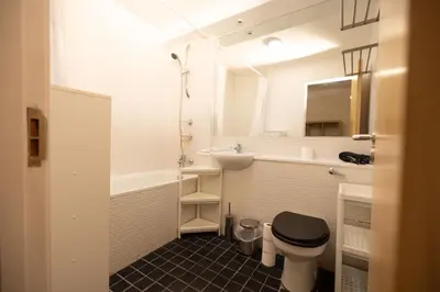 a white bathroom with a toilet and a sink at Muirhouse 2BR Apartment with Free Parking in Glasgow