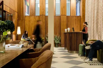 a woman standing at a podium in a lobby at The Wellington Glasgow by Adina in Glasgow