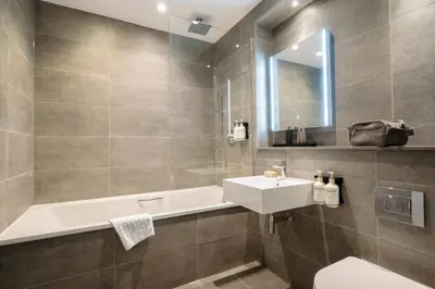 a bathroom with a sink and a bath tub at The Wellington Glasgow by Adina in Glasgow