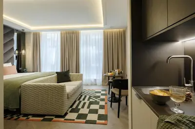 a bedroom with a bed and a kitchen with a table at The Wellington Glasgow by Adina in Glasgow