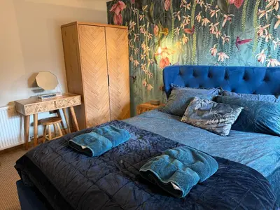 a blue bed with two pillows on top of it at Distillers Cottage, Peaceful rural retreat in Lanarkshire, onsite craft distillery, hot tub, bbq hut, central for exploring Scotland in Forth