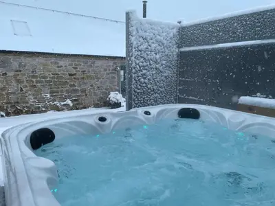 a jacuzzi tub with snow on the ground at Distillers Cottage, Peaceful rural retreat in Lanarkshire, onsite craft distillery, hot tub, bbq hut, central for exploring Scotland in Forth
