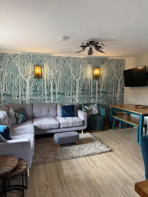 a living room with a couch and a table at Distillers Cottage, Peaceful rural retreat in Lanarkshire, onsite craft distillery, hot tub, bbq hut, central for exploring Scotland in Forth