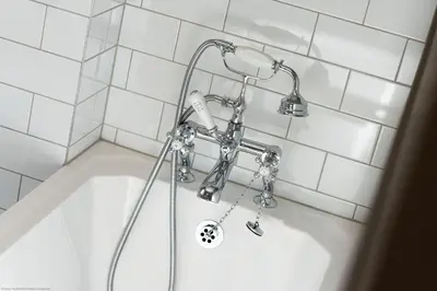 a shower in a white tiled bathroom with a tub at Stables Cottage in Dunira