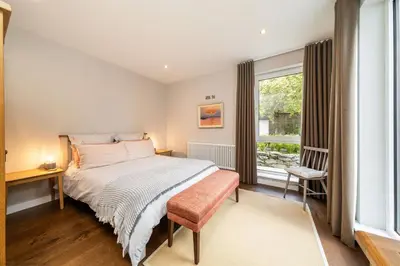 a bedroom with a bed and a window at Stables Cottage in Dunira