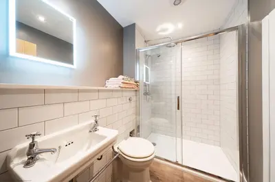 a bathroom with a toilet and a sink and a shower at Stables Cottage in Dunira