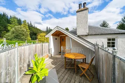 a wooden deck with a wooden table and chairs at The Granary in Dunira