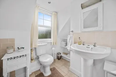 a white bathroom with a toilet and a sink at Stunning 2 Bed Riverside Cottage near Oban in Oban