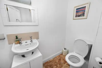 a white bathroom with a toilet and a sink at Stunning 2 Bed Riverside Cottage near Oban in Oban