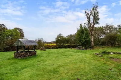 a gazebo in a grass field with a tree at Stunning 2 Bed Riverside Cottage near Oban in Oban