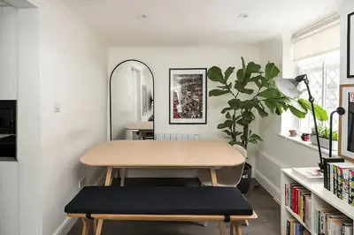 a table and bench in a room with a plant at 1 Bed Flat in Shoreditch near Station by Hostroo in Moffat