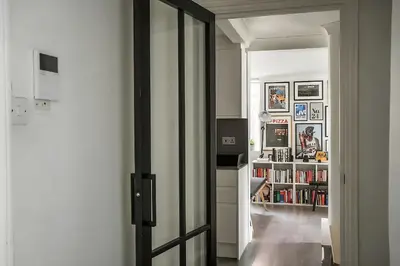 an open door to a room with a book shelf at 1 Bed Flat in Shoreditch near Station by Hostroo in Moffat